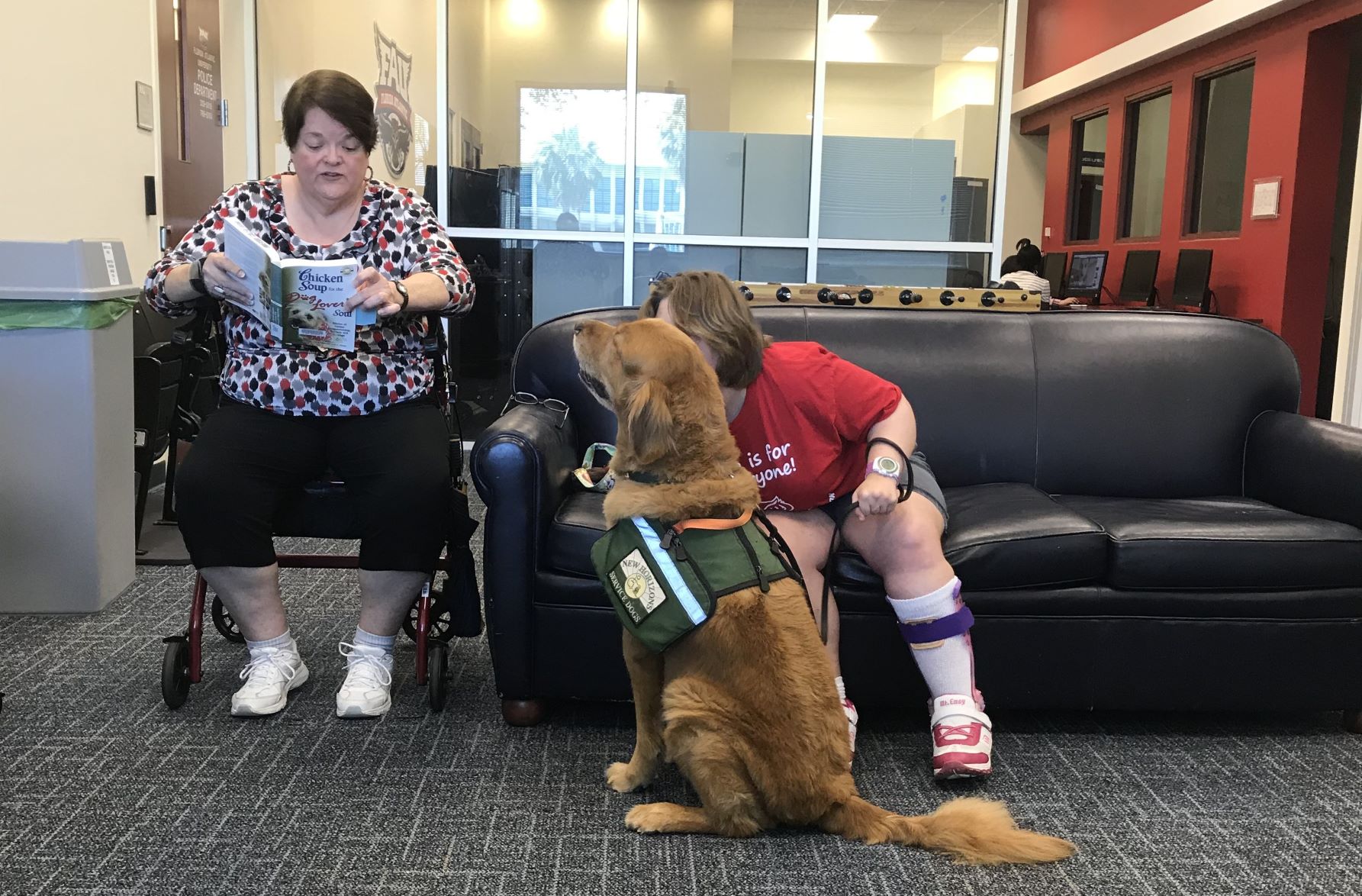 Book club members reading to the service dog Clay