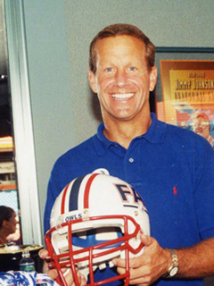 Photograph of Frank T. Brogan holding a FAU football helmet