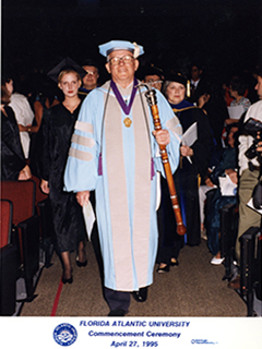Photograph of a university member dressed in commencement gowns